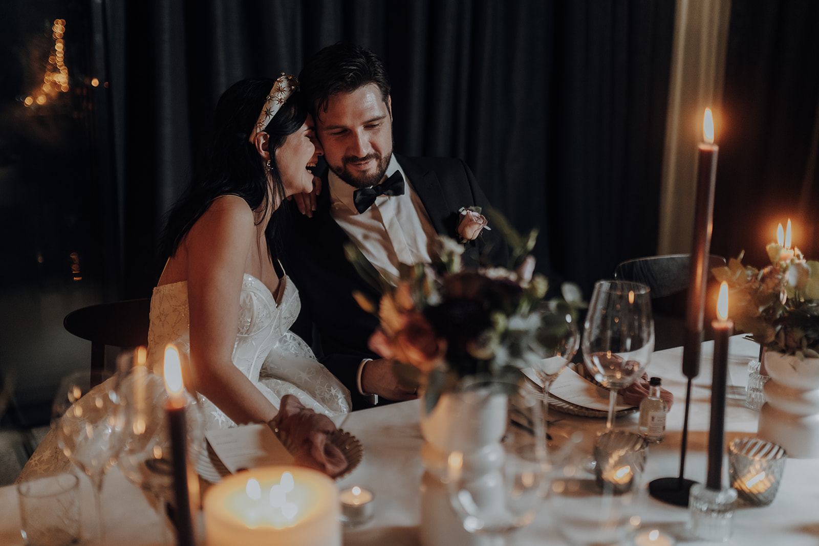 A couple sharing a quiet moment at their candlelit wedding reception